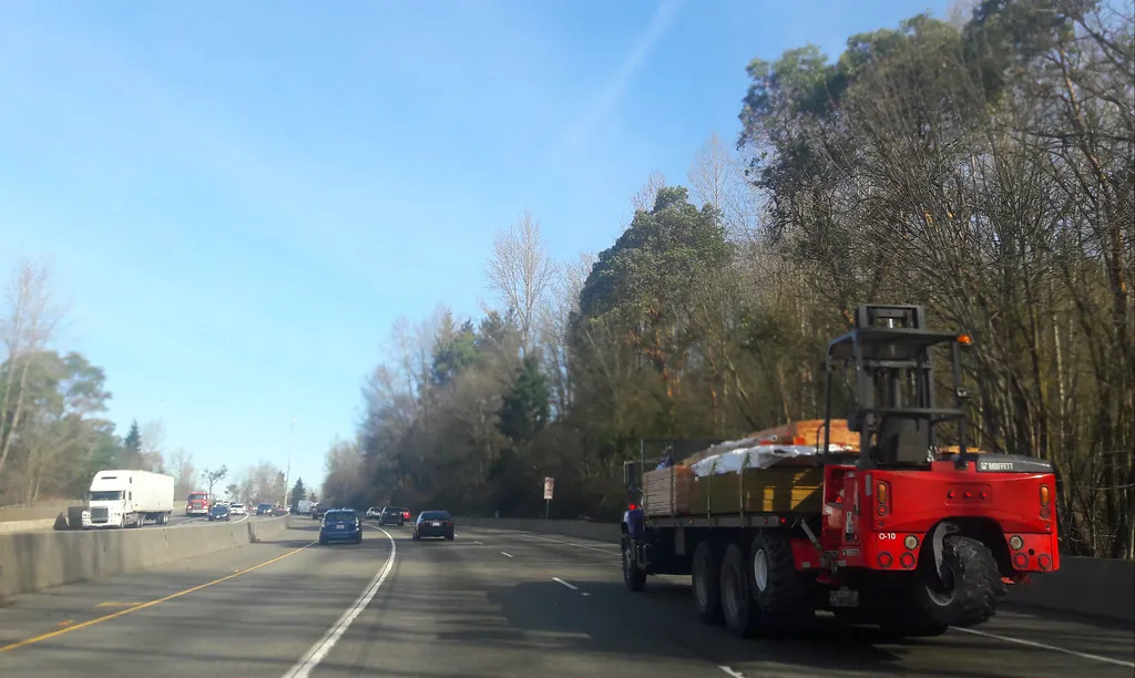 Ilustração de Modal rodoviário — Red delivery truck, highway 405, coming into Bellevue, Mercer Slough Nature Park, Norwood Village trees, Washington, USA