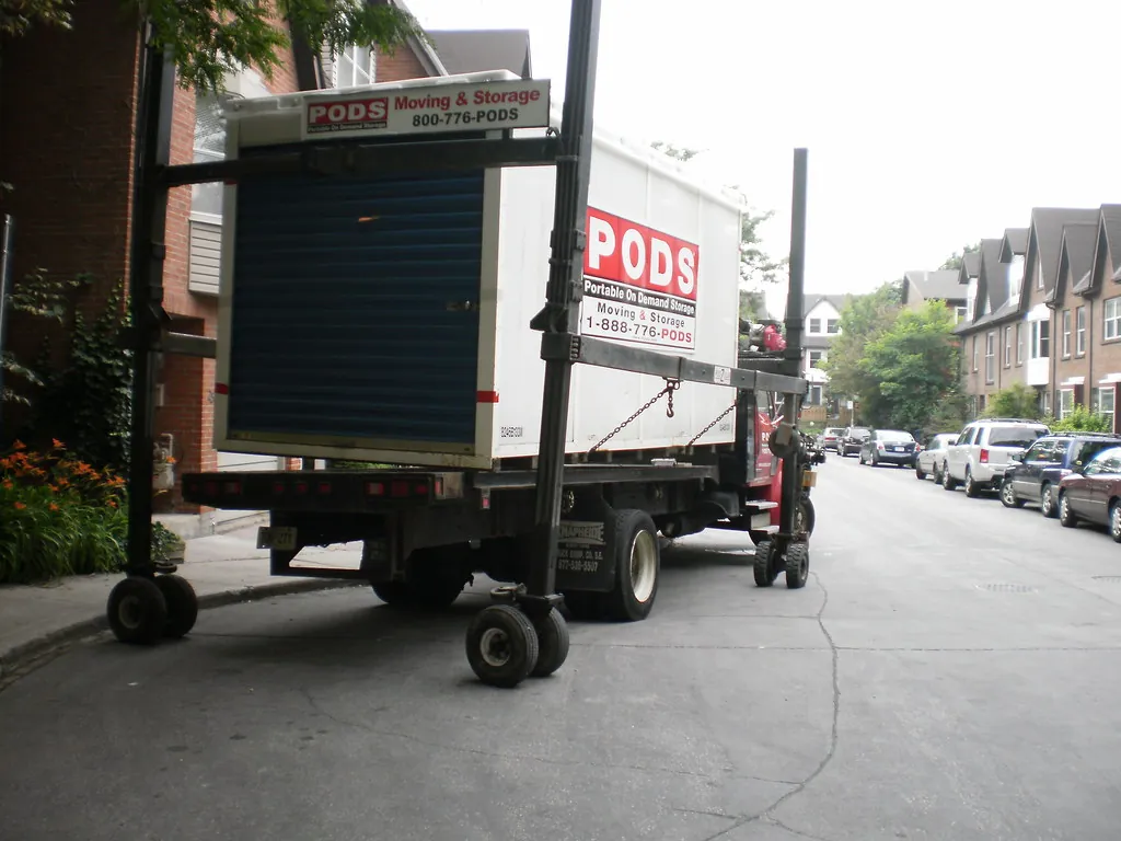 Ilustração de NVOCC — Unloading a shipping container with household contents -d